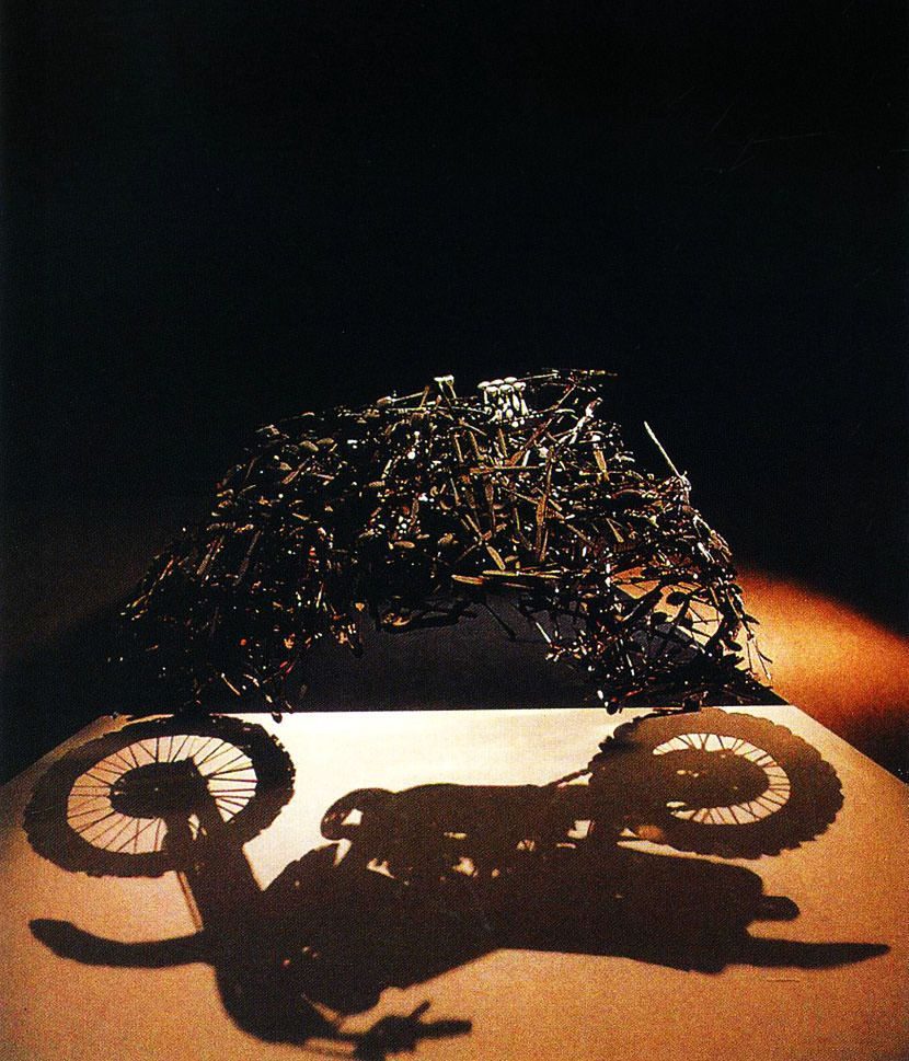 Lunch With a Helmet On sculpture 1987 — cutlery assemblage casting motorcycle shadow — Shigeo Fukuda